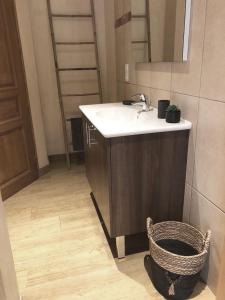 a bathroom with a sink and a mirror and a basket at Villa familiale entre mer et montagne Corse in Soccia