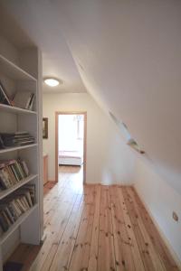 an attic room with a staircase and wooden floors at Chata pod klonami in Dziemiany