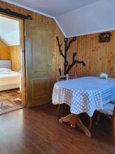 um quarto com uma mesa, uma cama e uma porta em Затишок в Карпатах em Slavske