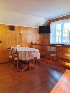 d'une salle à manger avec une table, des chaises et une fenêtre. dans l'établissement Затишок в Карпатах, à Slavsko