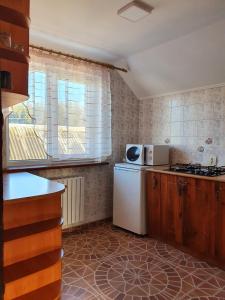 eine Küche mit einem weißen Kühlschrank und einem Fenster in der Unterkunft Затишок в Карпатах in Slawske