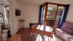 salon z drewnianym stołem i kanapą w obiekcie Residence Les Ecrins w mieście Puy-Saint-Vincent