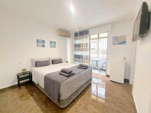 Un dormitorio con una cama grande y una mesa. en Gloria Host House, en Alicante