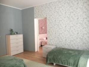 a bedroom with two beds and a dresser and a mirror at Allika külalistemaja 
