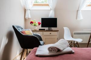 a room with a bed and two chairs and a television at Vági Apartment in Sárvár