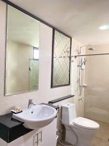 een badkamer met een wastafel, een toilet en een douche bij DE LUXE BOUTIQUE & rooftop in Chiang Mai