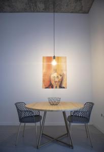埃斯帕戈斯的住宿－Apartamento encantador com pequeno pátio escondido，一张餐桌,配有两把椅子和一幅画