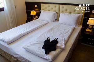 a bed with two black robes sitting on it at GREEN GARDEN Resort - Smart Hotel in Mestre