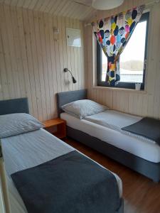 a small room with two beds and a window at Perła Szotlandu II in Władysławowo