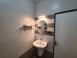 W łazience znajduje się umywalka i lustro. w obiekcie Richard Inn Residency w mieście Calangute
