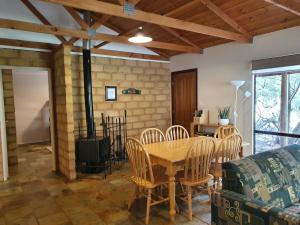 a dining room with a wooden table and chairs at Little River Farm Cottages in Denmark