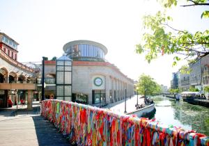 a fence with colorful ribbons on it next to a river at Domus da Ria - Teatro in Aveiro