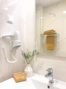 ein Badezimmer mit einem Waschbecken und einem Seifenspender in der Unterkunft Domus da Ria - Teatro in Aveiro + 11 Fotos