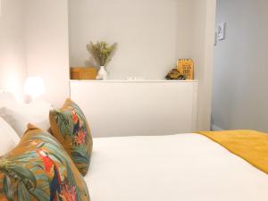 a bedroom with a white bed with a white headboard at Domus da Ria - Teatro in Aveiro