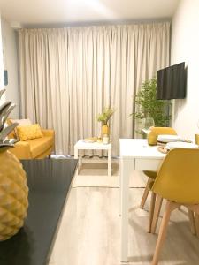 ein Wohnzimmer mit einem weißen Tisch und gelben Stühlen in der Unterkunft Domus da Ria - Teatro in Aveiro