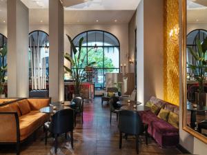 a restaurant with couches and tables and windows at The Dominican, Brussels, a Member of Design Hotels in Brussels