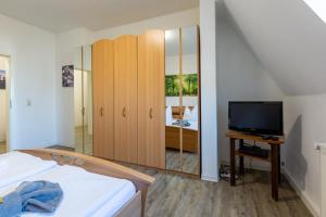 a bedroom with a bed and a tv and a dresser at Gästewohnung Weißwasser City in Weißwasser