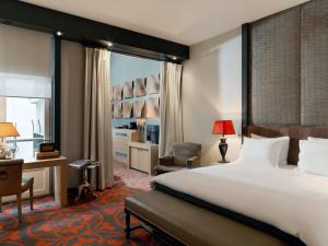 a hotel room with a bed and a desk and chair at The Dominican, Brussels, a Member of Design Hotels in Brussels