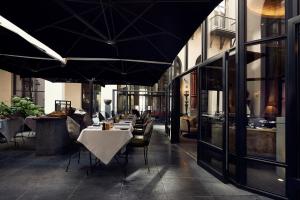 a restaurant with tables and chairs with umbrellas at The Dominican, Brussels, a Member of Design Hotels in Brussels