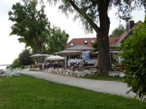 een groep tafels en parasols in een park bij Genusszeit am Chiemsee in Übersee