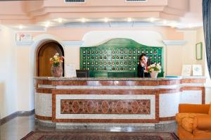 a woman standing at a counter in a lobby at Le Residenze del Golfo di Orosei in Orosei +36 photos