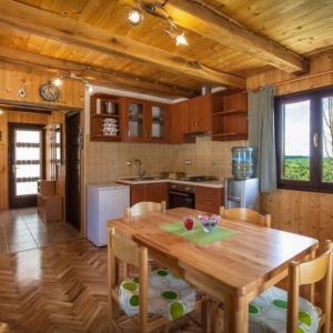 eine Küche mit einem Holztisch und einigen Stühlen in der Unterkunft Holiday home in Rakovica with terrace, WiFi, washing machine 4488-2 in Rakovica