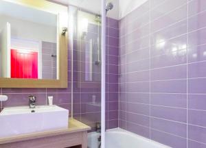 a purple bathroom with a sink and a bath tub at Great condo between golf course and beach in Moliets-et-Maa