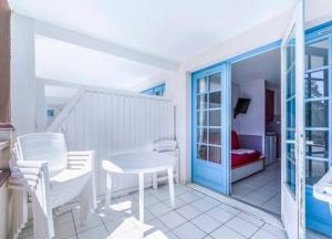 a room with a table and chairs and a bedroom at Great condo between golf course and beach in Moliets-et-Maa