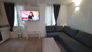 a living room with a couch and a flat screen tv at Studio Neuf Climatisé Centre Ville #6 in Toulon +2 photos