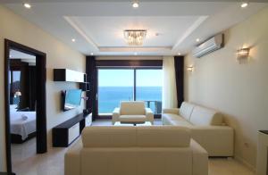 a living room with a couch and a bedroom at Shine residence in Budva