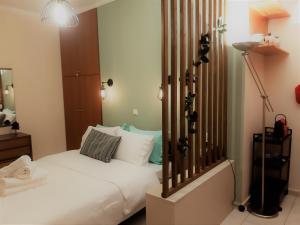 una camera con letto bianco e lampada di Όμορφο Studio στην πόλη Πάτρα a Patra