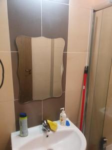 ein Bad mit einem Waschbecken und einem Spiegel in der Unterkunft Синьо небе in Bansko