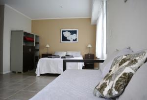 a hotel room with two beds and a desk at Florencia Departamentos in Tandil