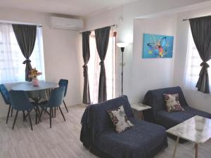 a living room with a couch and a table and chairs at Happiness Apartment Center in Bitola