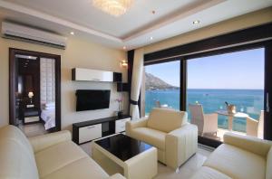 a living room with white furniture and a large window at Shine residence in Budva