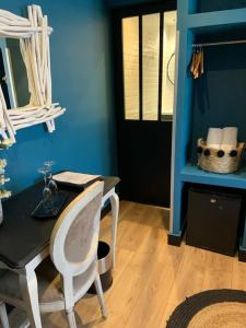 ein blaues Zimmer mit einem Schreibtisch und einem Stuhl in der Unterkunft Be Cottage Hotel in Le Touquet-Paris-Plage + 62 Fotos