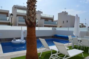 a pool with chairs and a palm tree on a roof at Palmeras Gold - Moderne villa (6p) met solarium/privézwembad in San Pedro del Pinatar
