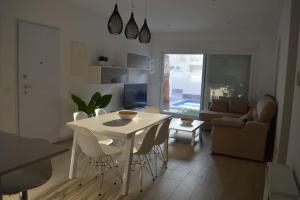 a kitchen and living room with a white table and chairs at Palmeras Gold - Moderne villa (6p) met solarium/privézwembad in San Pedro del Pinatar