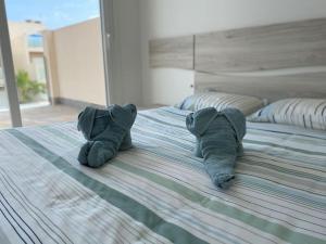 a pair of slippers on top of a bed at Palmeras Gold - Moderne villa (6p) met solarium/privézwembad in San Pedro del Pinatar +25 photos