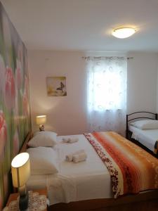 a bedroom with two beds and a window at Apartments Marlen in Mali Lošinj