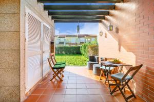 um pátio com uma mesa e cadeiras e uma parede de tijolos em Furadouro Sunny Family Villa em Ovar