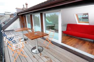 a balcony with a red couch and a table and chairs at Luxury Apartments by Livingdowntown in Zurich