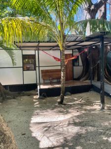 a building with a bench and a palm tree at Beach Cabinas in Santa Teresa Beach