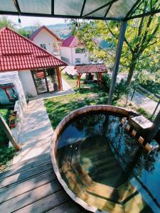 una terraza de madera con vistas a una piscina. en Pensiunea Daniela, en Moisei