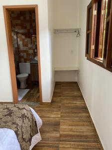 a room with a bathroom with a bed and a toilet at Pousada da Villa in Sao Jorge
