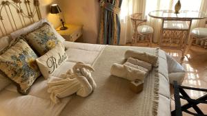 - un canapé blanc avec des serviettes dans le salon dans l'établissement Estancia Don Pedro, à San Antonio de Areco