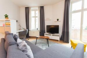 a living room with a couch and a tv at FullHouse - Halle - AB7 Apartments - City Center in Halle an der Saale