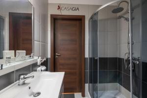a bathroom with a sink and a shower and a mirror at Pension Casa Gia in Cluj-Napoca