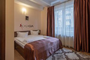 a bedroom with a bed and a large window at Pension Casa Gia in Cluj-Napoca