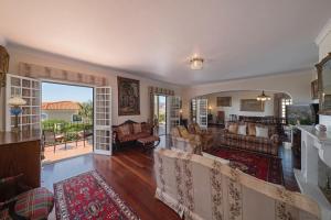 ein Wohnzimmer mit Stühlen und ein Wohnzimmer mit Kamin in der Unterkunft OurMadeira - Villa Vista Sol, grand traditional in São Gonçalo